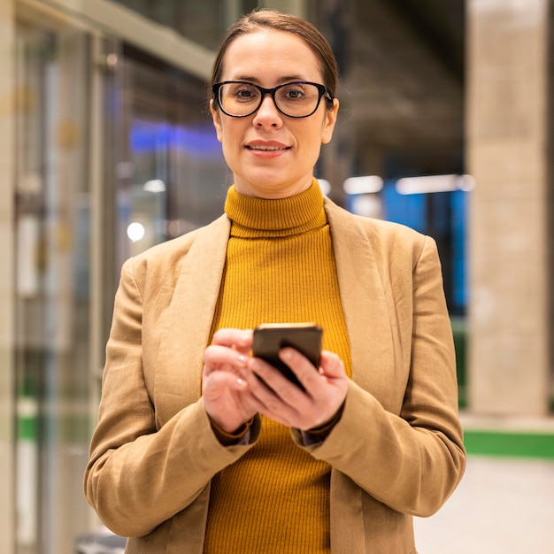 Mulher de tiro médio segurando o telefone