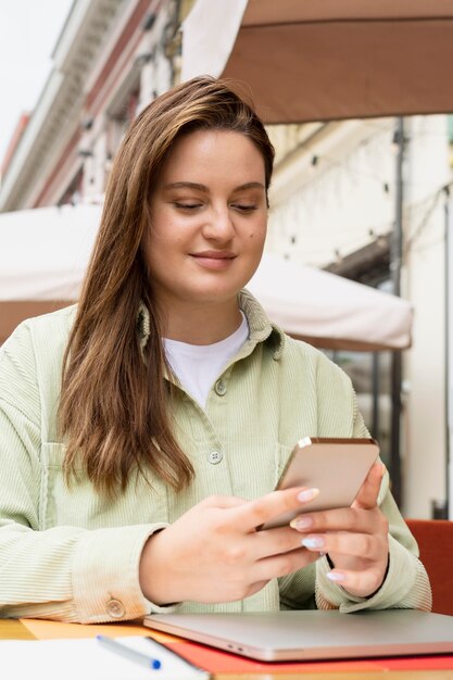 Mulher de tiro médio segurando o telefone