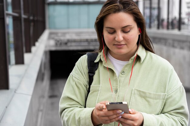 Mulher de tiro médio segurando o telefone