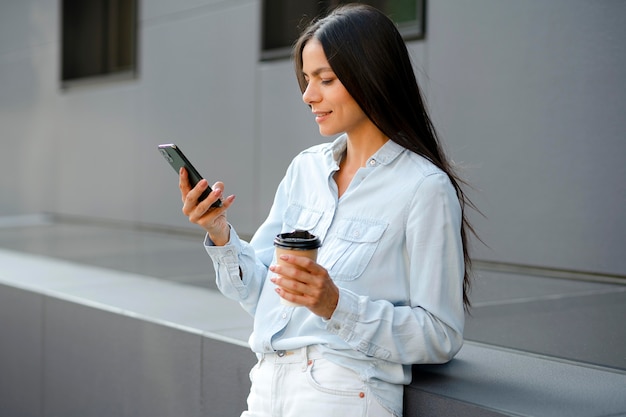 Foto grátis mulher de tiro médio segurando o telefone