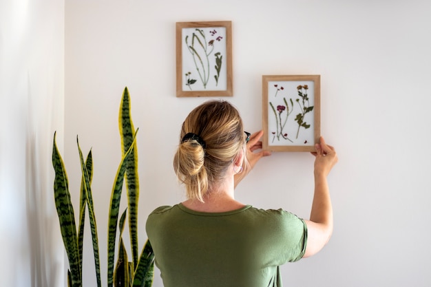 Mulher de tiro médio segurando quadro