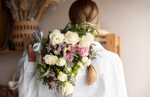 Foto grátis mulher de tiro médio segurando um buquê de flores