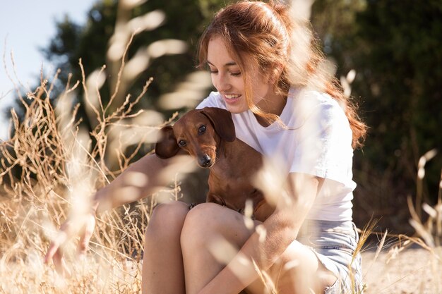 Mulher de tiro médio segurando um cachorro fofo