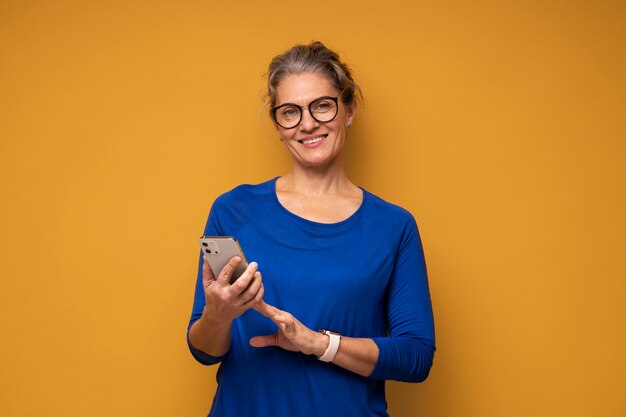 Mulher de tiro médio segurando um smartphone