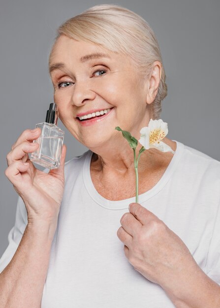 Mulher de tiro médio segurando uma flor e uma garrafa