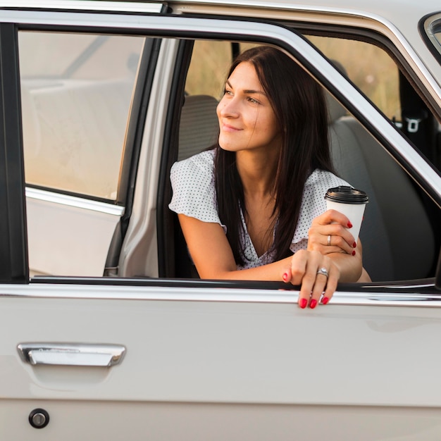 Foto grátis mulher de tiro médio segurando uma xícara de café