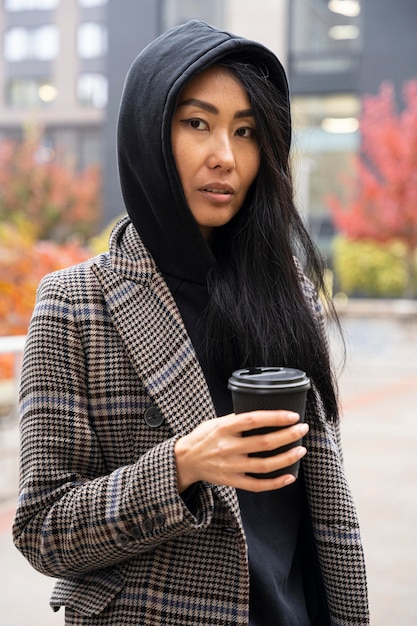 Mulher de tiro médio segurando uma xícara de café