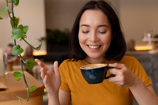 Mulher de tiro médio segurando uma xícara de café