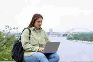 Foto grátis mulher de tiro médio sentada com um laptop