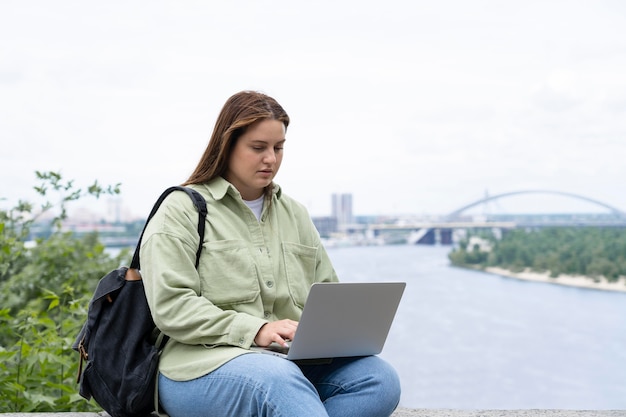 Mulher de tiro médio sentada com um laptop