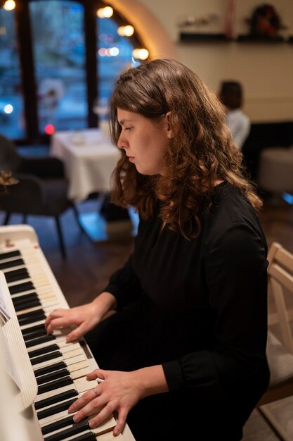 Mulher de tiro médio tocando piano