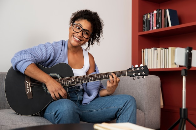 Mulher de tiro médio tocando violão