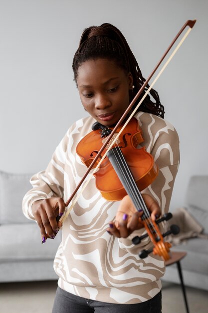 Mulher de tiro médio tocando violino