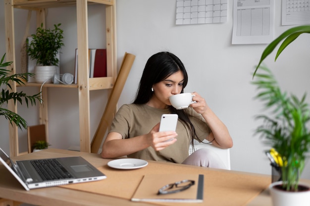 Mulher de tiro médio tomando café