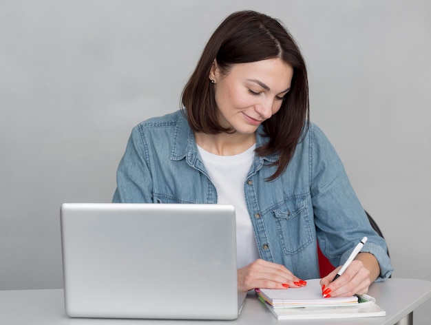 Mulher de tiro médio tomando notas