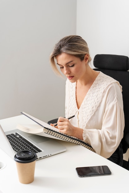 Mulher de tiro médio tomando notas