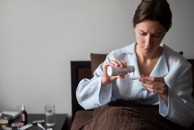 Mulher de tiro médio tomando remédio