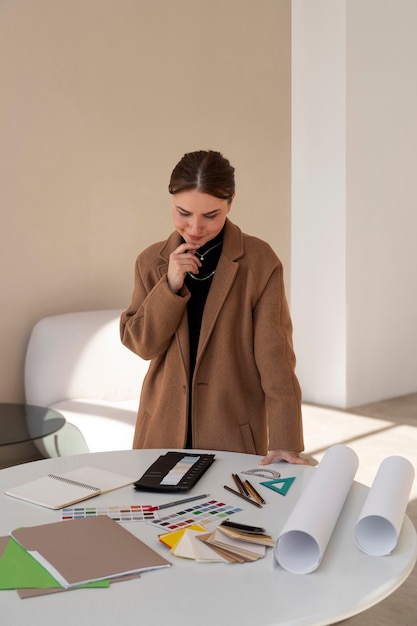 Mulher de tiro médio trabalhando em projeto de design de interiores