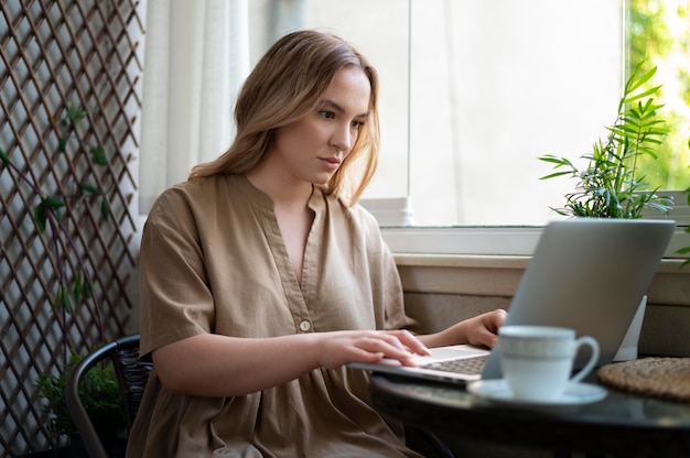 Mulher de tiro médio trabalhando em um laptop