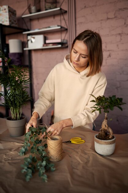 Mulher de tiro médio trabalhando em uma floricultura