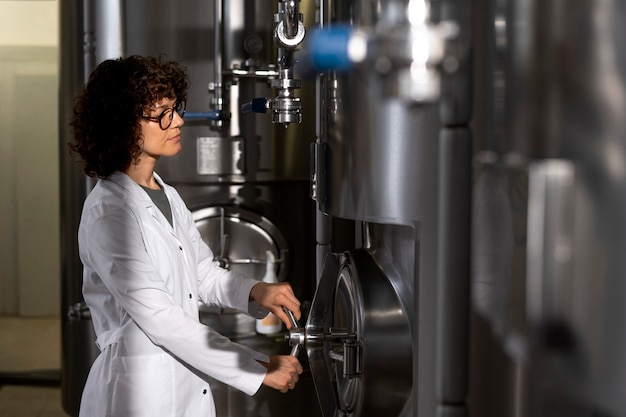 Mulher de tiro médio trabalhando na fábrica de cerveja