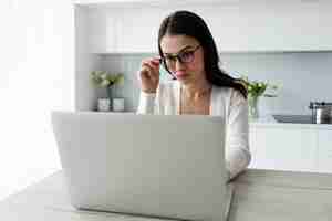 Foto grátis mulher de tiro médio trabalhando no laptop em casa