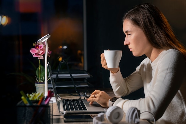 Mulher de tiro médio trabalhando tarde da noite