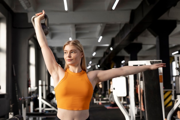 Mulher de tiro médio treinando na academia