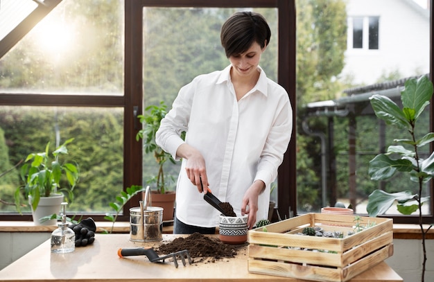 Mulher de tiro médio usando colher de jardinagem