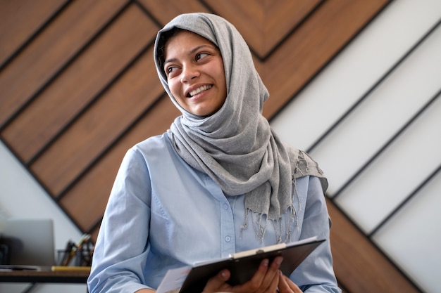 Foto grátis mulher de tiro médio usando hijab no trabalho