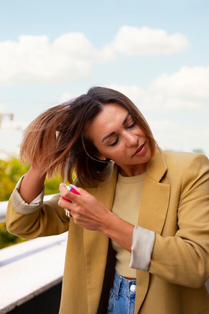 Mulher de tiro médio usando xampu seco ao ar livre