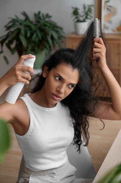 Foto grátis mulher de tiro médio usando xampu seco em casa