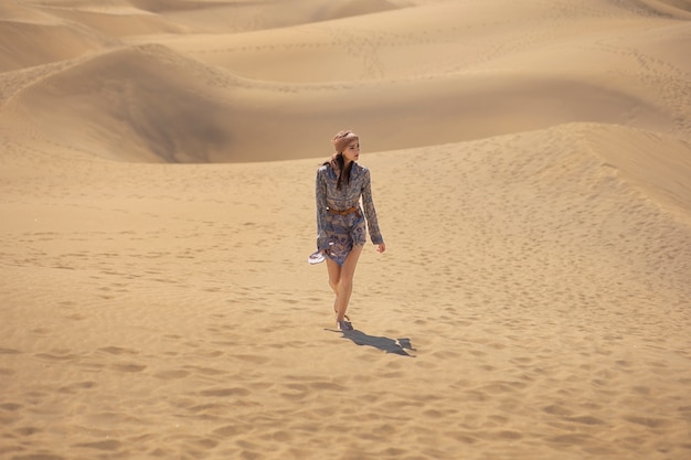 Mulher de tiro no escuro andando no deserto