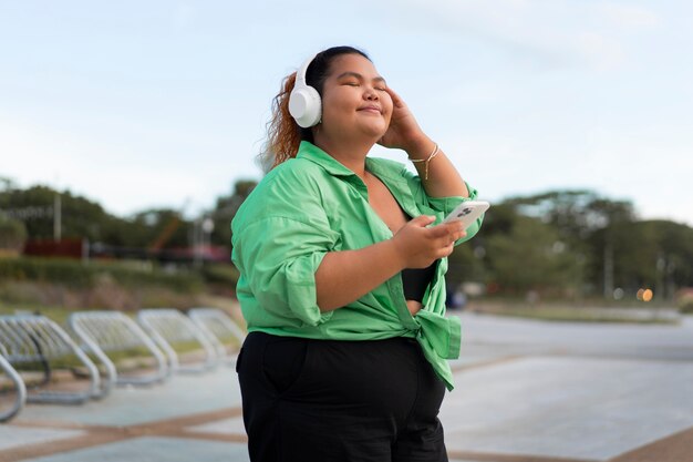 Mulher de tom médio usando fones de ouvido