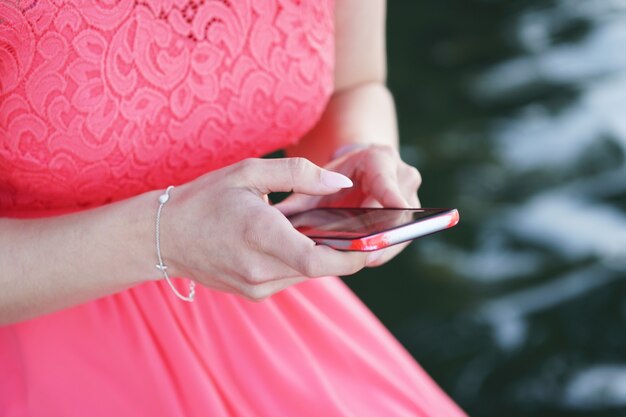 Mulher de vestido segurando um smartphone