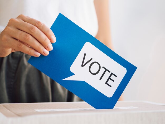 Mulher de vista frontal, colocando uma mensagem de voto em uma caixa de close-up