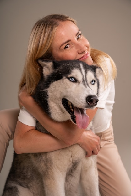 Foto grátis mulher de vista frontal com cachorro em estúdio