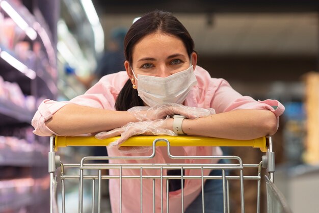 Foto grátis mulher de vista frontal fazendo compras com máscara facial