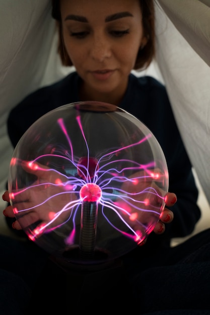 Foto grátis mulher de vista frontal interagindo com uma bola de plasma