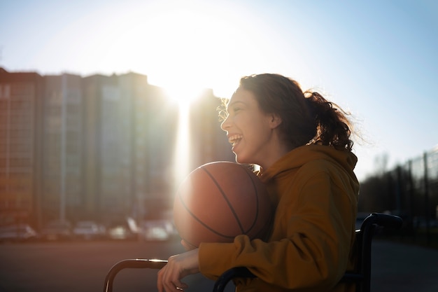 Foto grátis mulher de vista lateral em cadeira de rodas jogando basquete