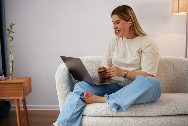 Foto grátis mulher de vista lateral fazendo videochamadas com laptop