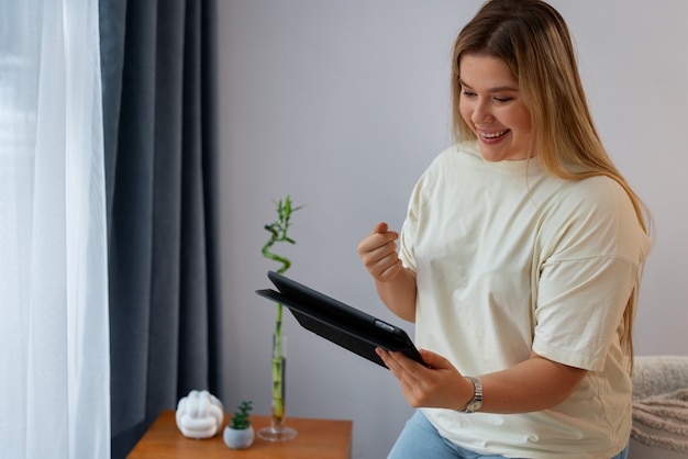 Foto grátis mulher de vista lateral fazendo videochamadas com tablet