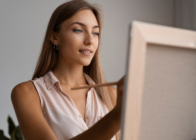 Foto grátis mulher de vista lateral pintando em casa