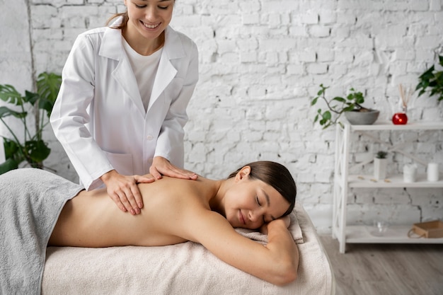 Foto grátis mulher de vista lateral sendo massageada no spa