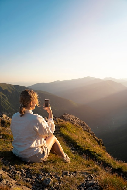 Foto grátis mulher de vista lateral tomando selfie na montanha