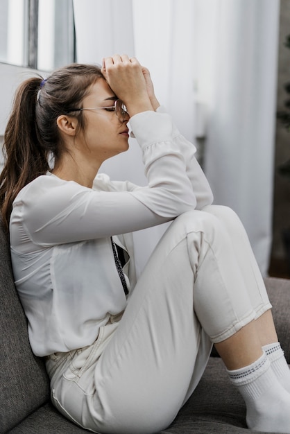 Foto grátis mulher de vista lateral triste enquanto trabalha em casa