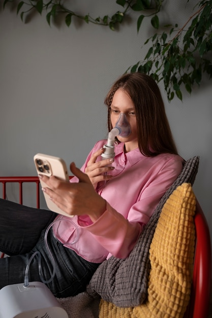 Foto grátis mulher de vista lateral usando nebulizador em casa