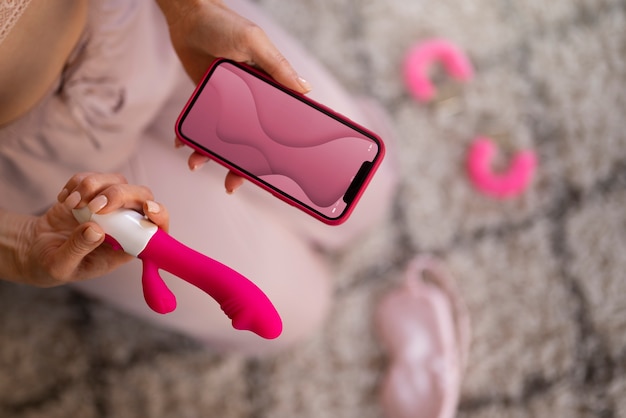 Mulher de vista superior com smartphone e vibrador