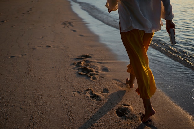 Mulher de vista traseira caminhando na praia
