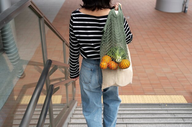 Mulher de vista traseira com bolsa de tecido